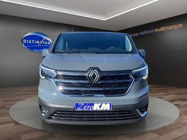 Vue frontale du Renault Trafic Cabine Approfondie gris urbain avec calandre chromée et projecteurs LED allumés.