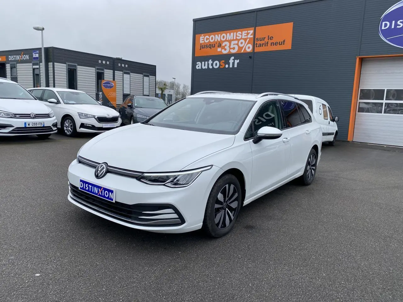 Volkswagen Golf SW 2.0 TDI blanc oryx vue 3/4 avant droit avec vitres arrière surteintées et jantes spécifiques.
