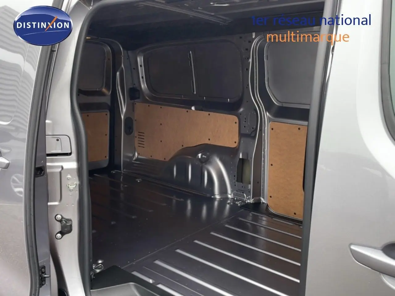 Vue intérieure arrière du Citroën Jumpy gris Artense Metal, montrant l’espace de chargement vide avec parois partiellement protégées.