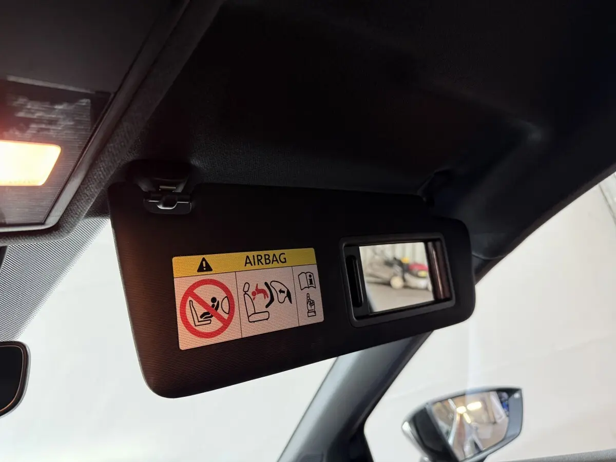 Détail du pare-soleil côté conducteur avec miroir et avertissement airbag dans une SEAT Ibiza noire 2024.