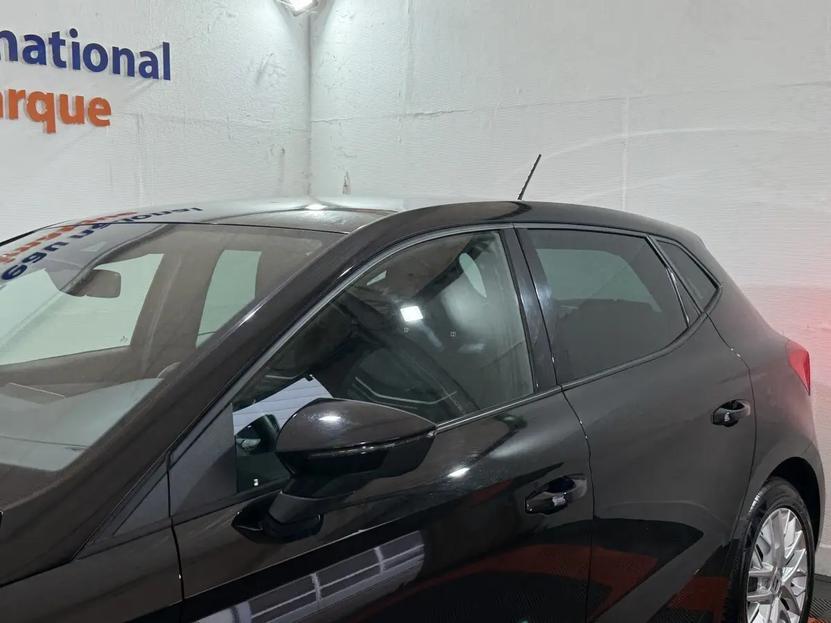 Vue latérale droite d'une SEAT Ibiza 1.0 TSI 110 FR noire, avec rétroviseurs ton caisse et jantes alliage visibles.