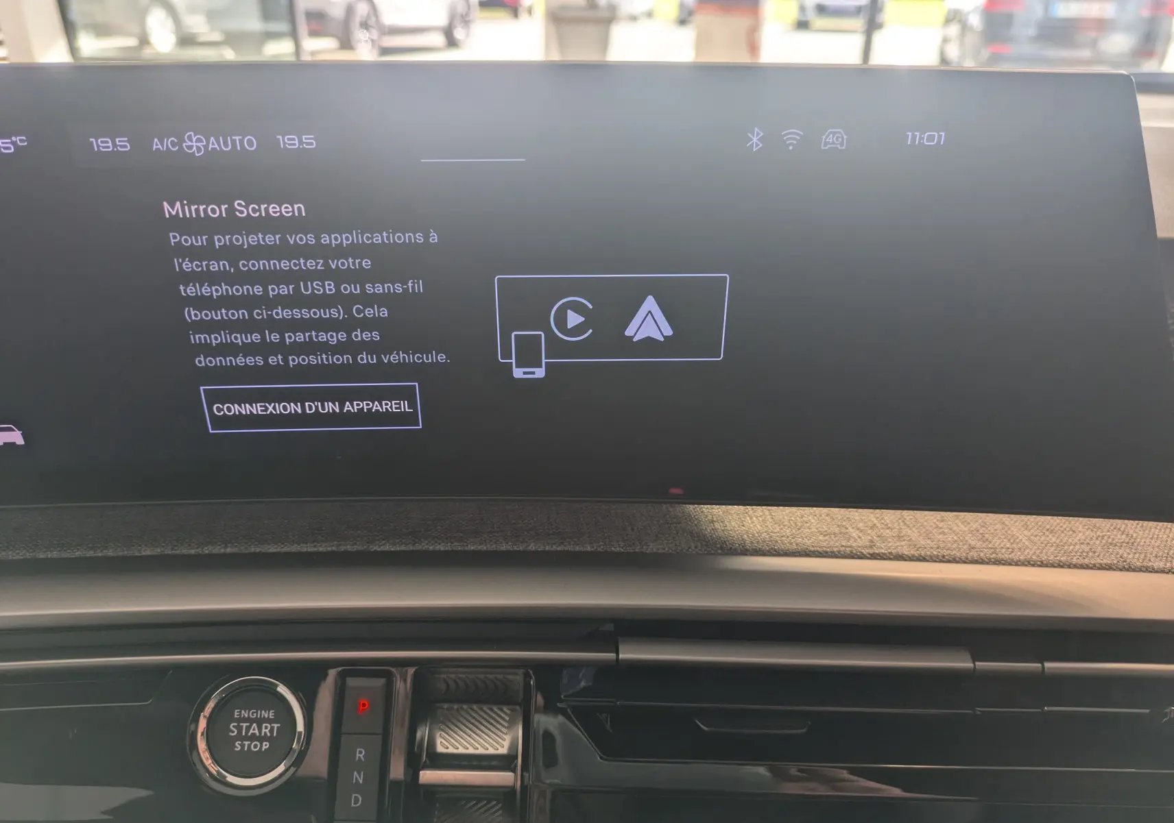 Vue rapprochée du tableau de bord de la Peugeot 5008 hybride 2025 avec écran tactile Mirror Screen et bouton start/stop.