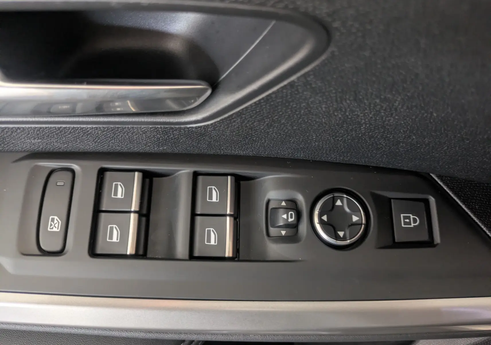 Gros plan sur les commandes de lève-vitres et rétroviseurs côté conducteur du Peugeot 5008 gris titane 2025.