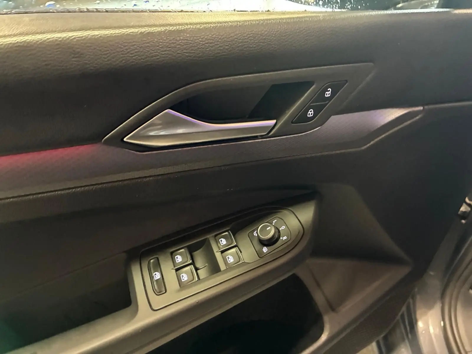 Détail de la porte côté conducteur d’une Volkswagen Golf gris 2022, avec commandes électriques des vitres et verrouillage.
