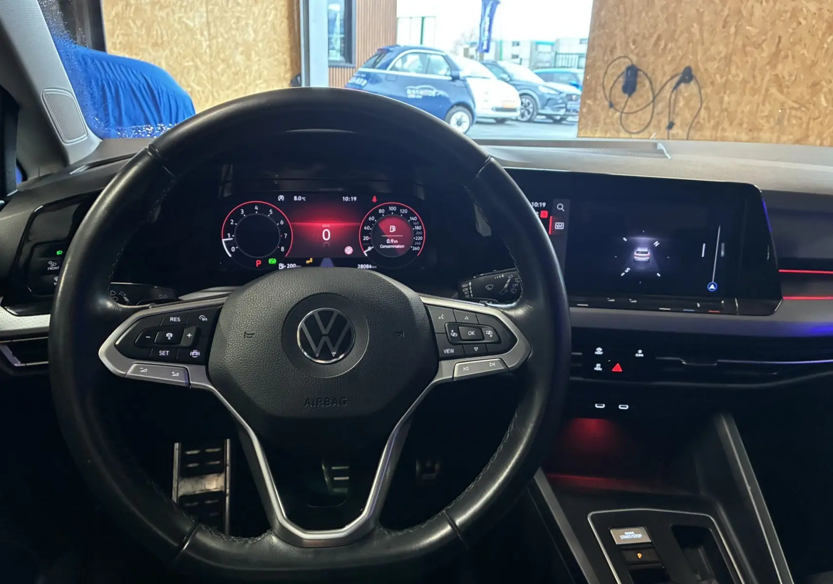 Vue intérieure centrée sur le volant noir de la Volkswagen Golf 1.5 eTSI 130 DSG7 Active avec tableau de bord numérique et écran tactile.