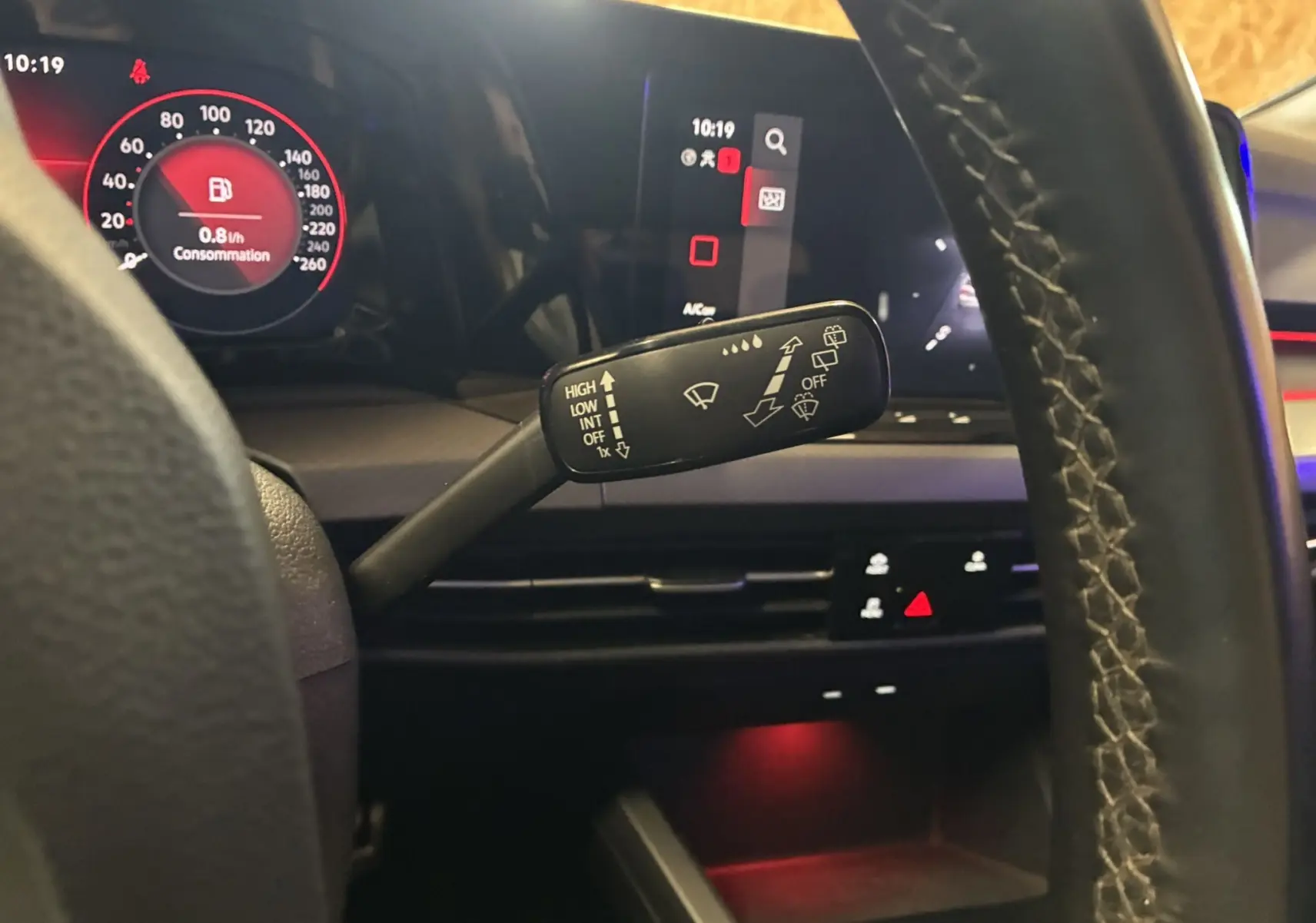 Gros plan sur la commande d’essuie-glace à gauche du volant dans l’habitacle noir d’une Volkswagen Golf gris 2022.