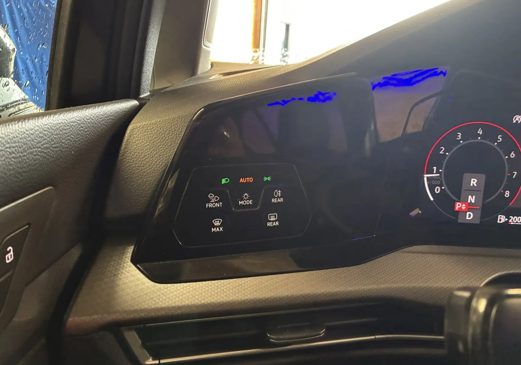 Vue rapprochée du tableau de bord côté gauche de la Volkswagen Golf gris 1.5 eTSI 130 DSG7 Active avec commandes éclairage et affichage digital.