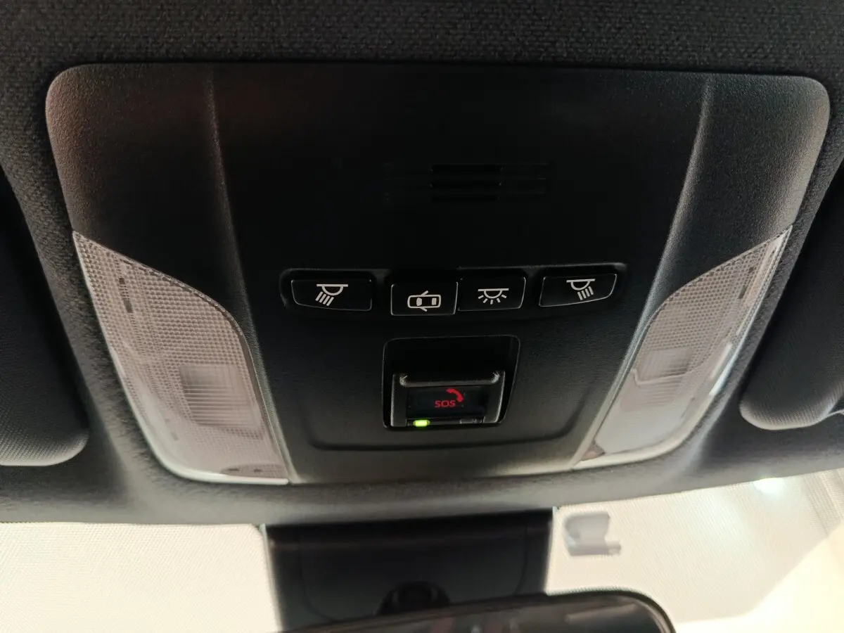 Vue en contre-plongée du plafonnier noir avec commandes d’éclairage et bouton SOS de la Toyota Corolla Hybride 2020.
