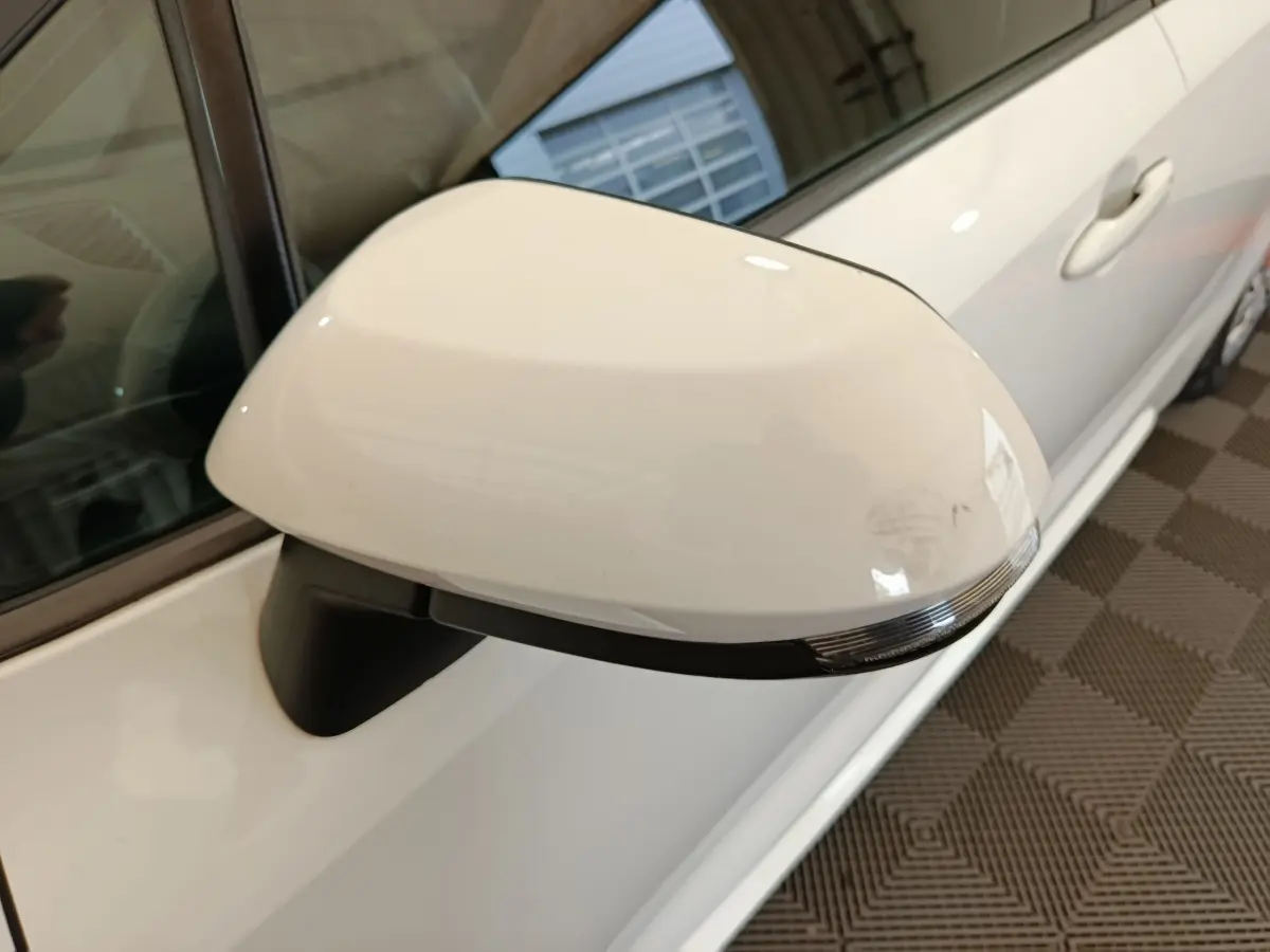 Rétroviseur côté gauche blanc de la Toyota Corolla Hybride 122h Active 2020, vue rapprochée en intérieur.