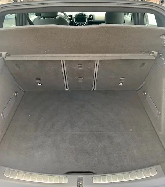 Coffre ouvert vu de l'arrière d'une MINI Countryman Cooper D 150ch gris 2017, montrant l'espace de chargement et l'intérieur.