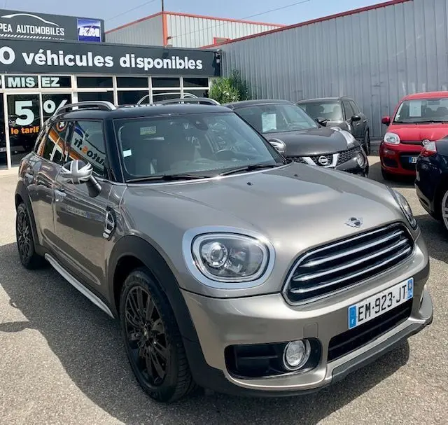 MINI Countryman Cooper D 150ch gris vue 3/4 avant droit, avec jantes noires et toit noir, stationné en extérieur.