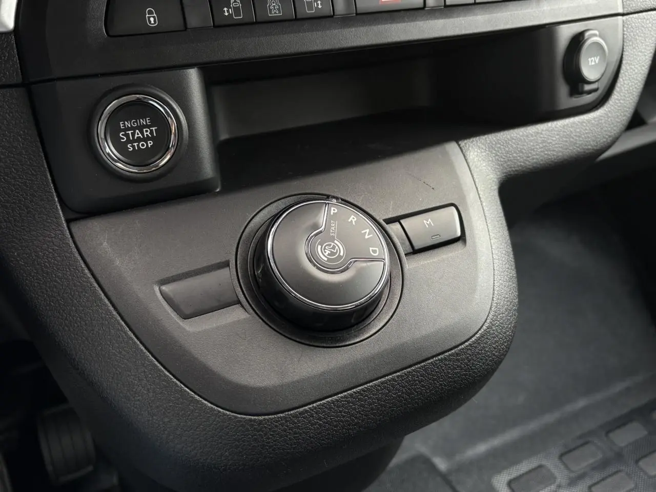 Gros plan sur la molette de boîte automatique et bouton start/stop dans l'habitacle noir de l'Opel Zafira Life XL 2024.