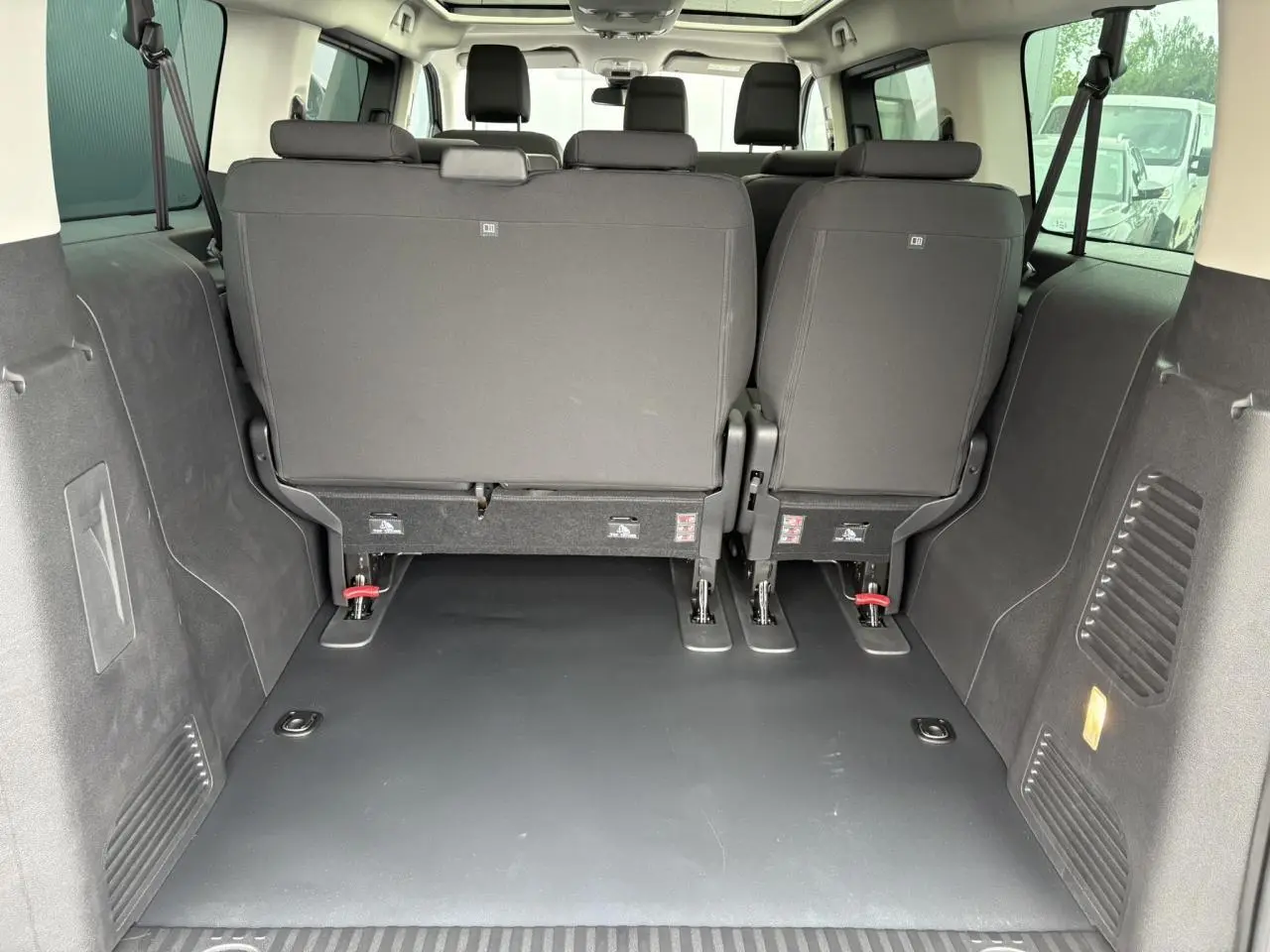 Vue arrière de l'habitacle de l'Opel Zafira Life XL gris Artense, montrant les sièges arrière et le toit panoramique.