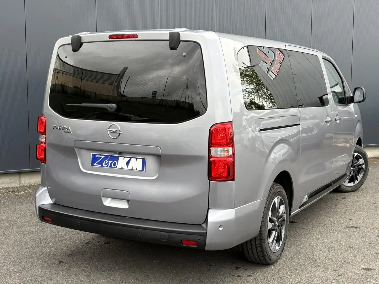 Vue 3/4 arrière droite d'un Opel Zafira Life XL gris Artense avec vitres teintées et jantes alliage.