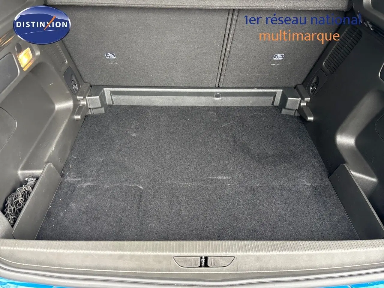 Coffre vide vu de l'arrière d'un Opel Grandland 2023 bleu Spektrum Metal avec revêtement noir et filet de rangement.