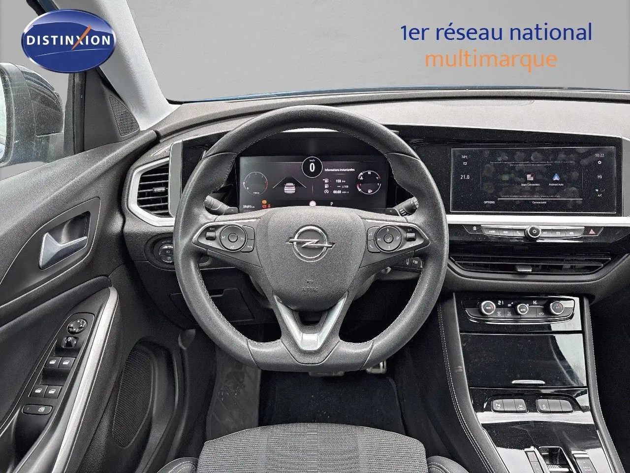 Vue intérieure frontale du poste de conduite de l'Opel Grandland 2023 avec tableau de bord numérique et volant cuir noir.