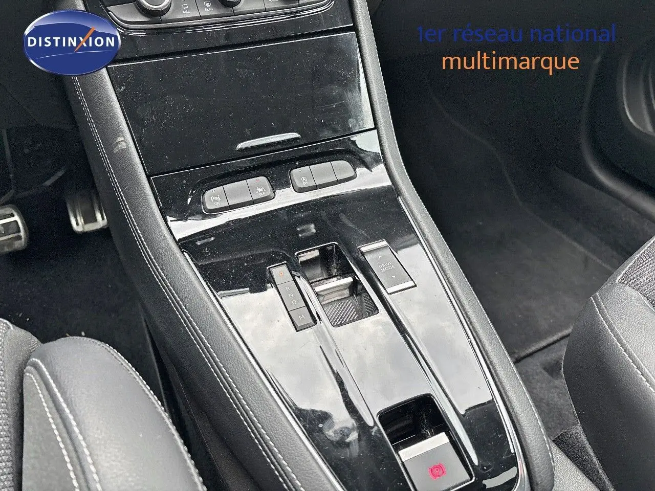 Gros plan sur la console centrale noire brillante de l'Opel Grandland 2023, avec levier de vitesses automatique et commandes.