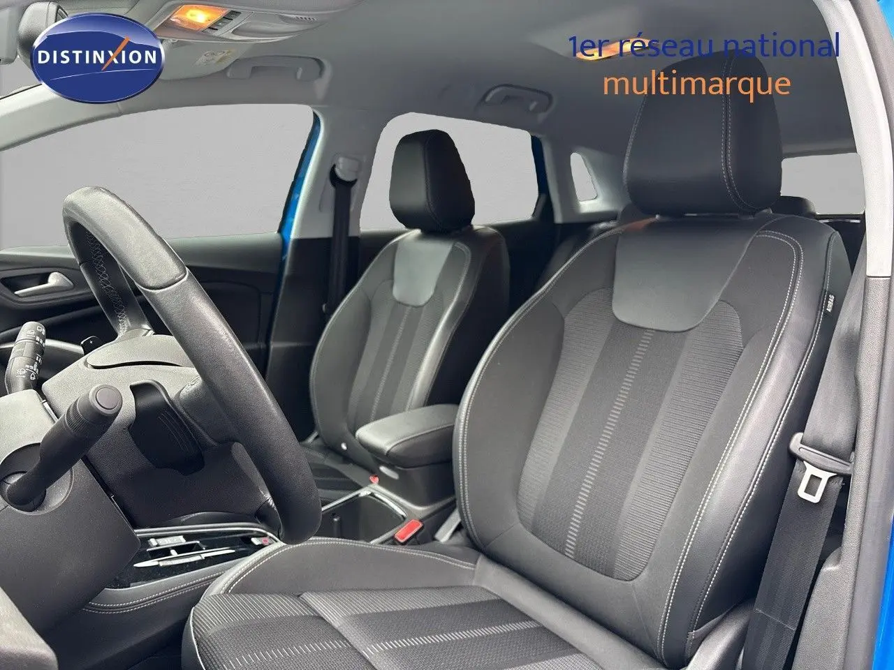 Intérieur de l’Opel Grandland 2023 en bleu Spektrum Metal, vue sur les sièges avant en cuir noir et volant côté gauche.