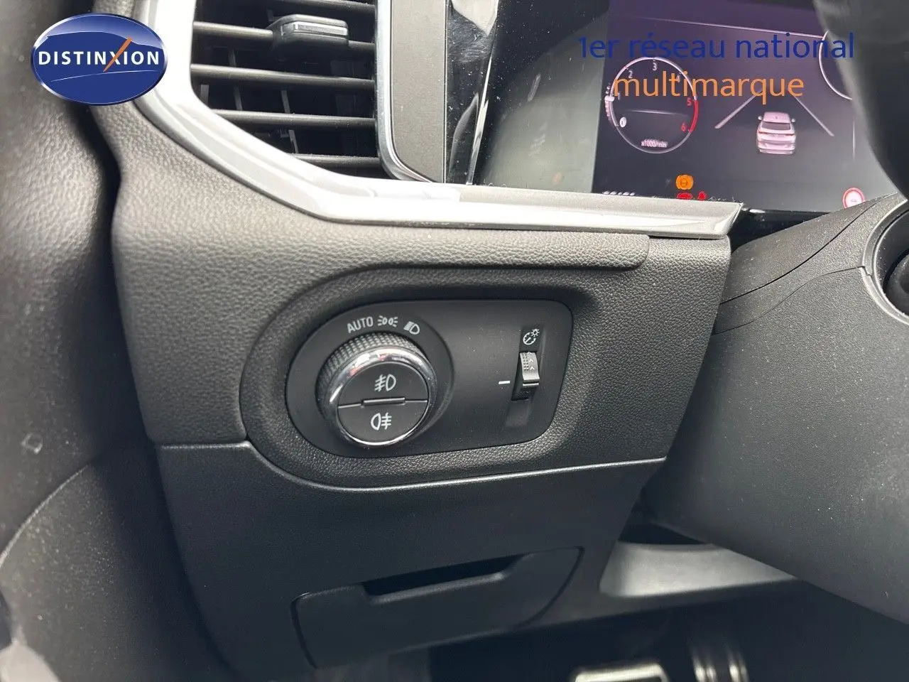 Gros plan sur le tableau de bord à gauche du volant de l'Opel Grandland 2023, avec commandes d'éclairage et réglage de phares.