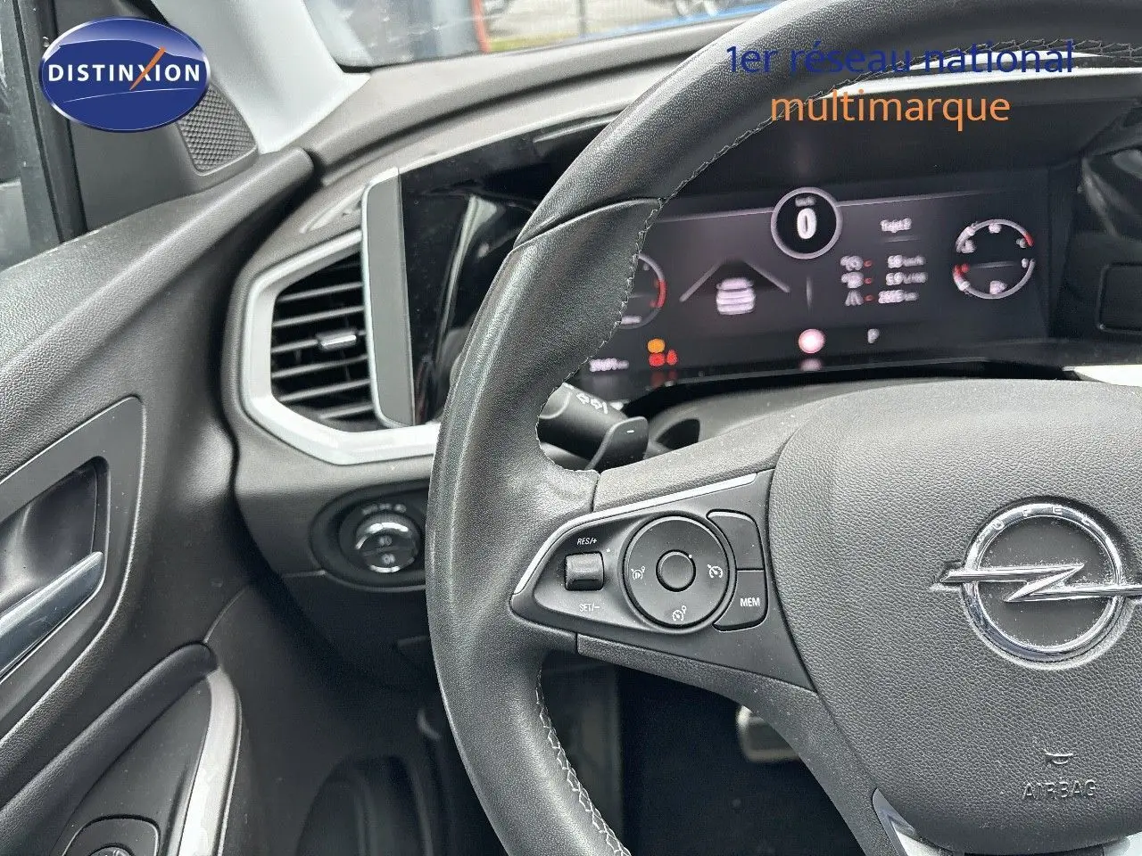 Vue rapprochée du volant et tableau de bord numérique d'un Opel Grandland bleu Spektrum Metal 2023, intérieur noir.