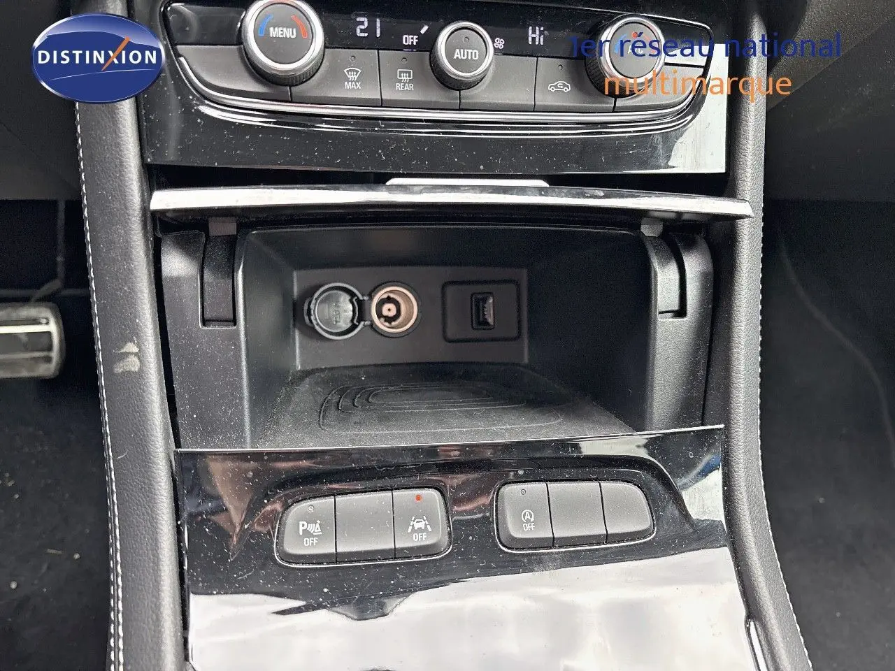 Vue rapprochée de la console centrale de l'Opel Grandland 2023, montrant les commandes de climatisation et prises USB et 12V.