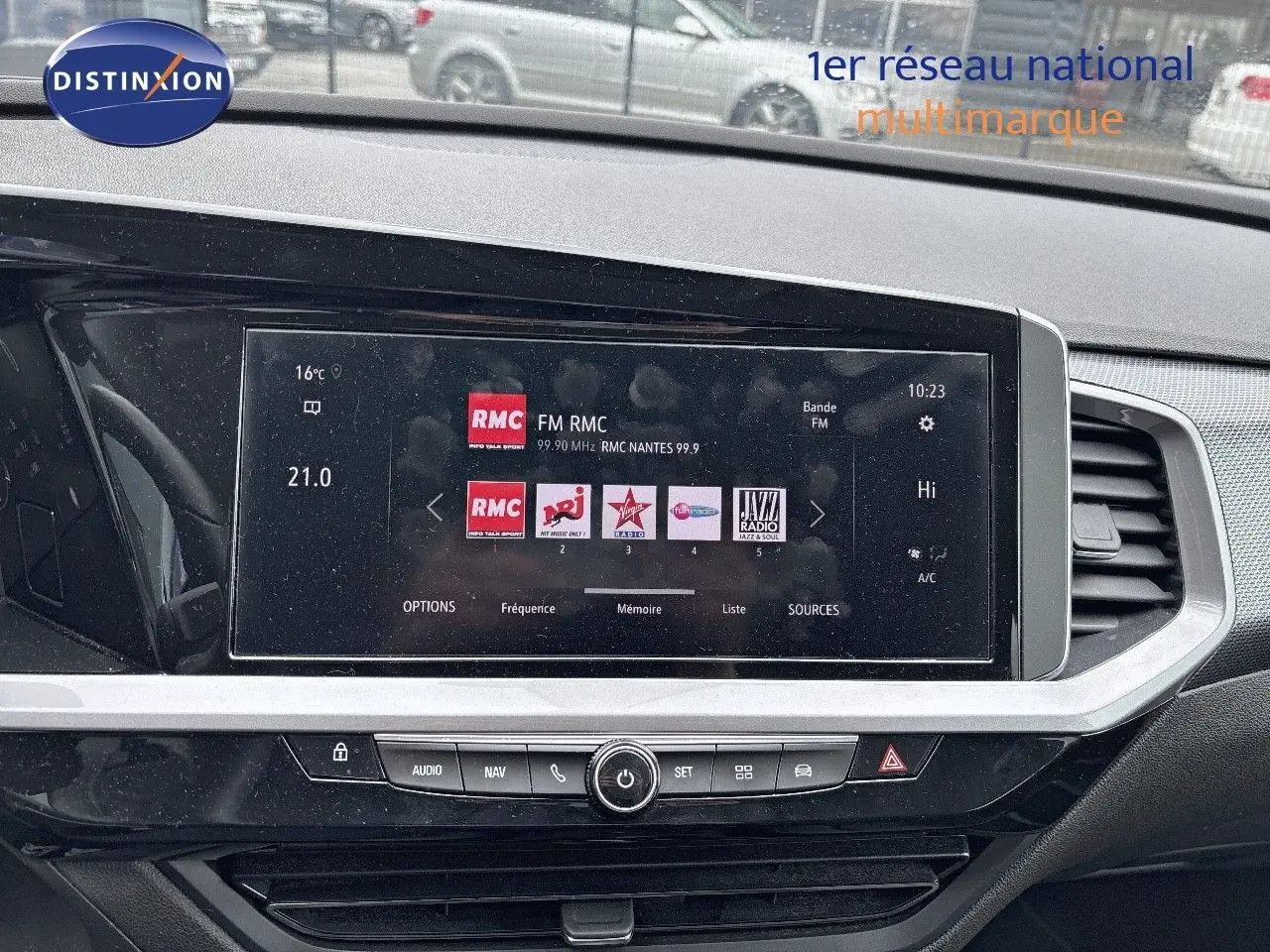 Tableau de bord de l'Opel Grandland 2023 avec écran tactile affichant stations radio, ambiance intérieure noire moderne.