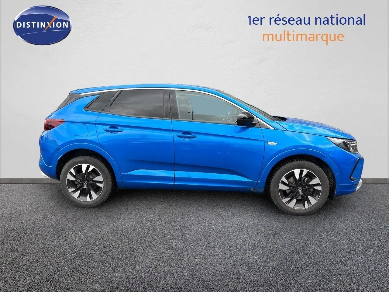 Profil droit d'un Opel Grandland 2023 bleu Spektrum Metal avec jantes alliage bicolores sur fond neutre.