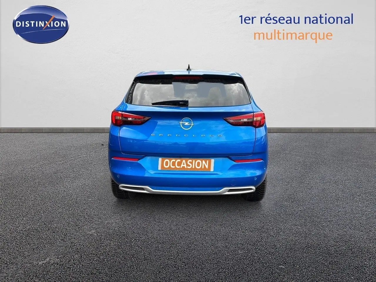 Vue arrière d'un Opel Grandland bleu Spektrum Metal avec plaque "OCCASION" sur fond neutre.