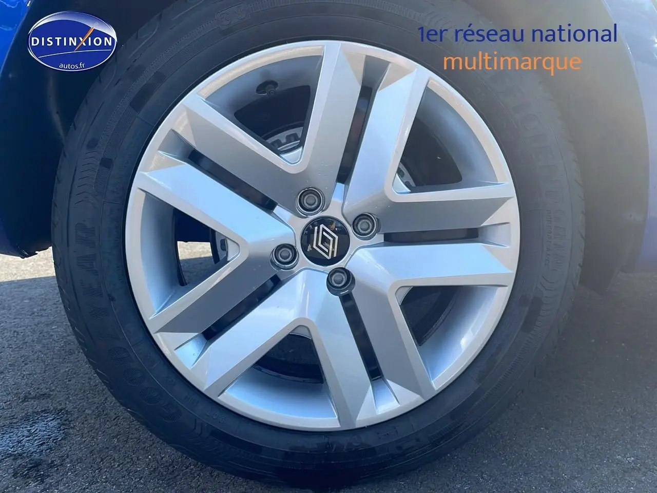 Gros plan sur la jante argentée de la Renault Clio V bleu iron, mettant en valeur le logo central et le pneu Goodyear.