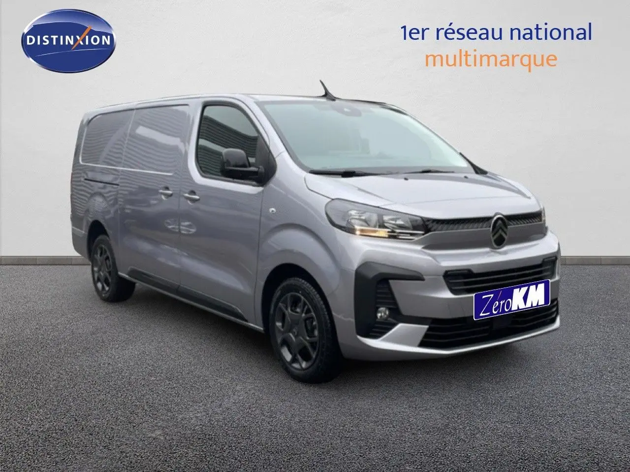 Vue 3/4 avant d’un Citroën Jumpy gris Artense métal, fourgon long avec calandre noire et jantes foncées.