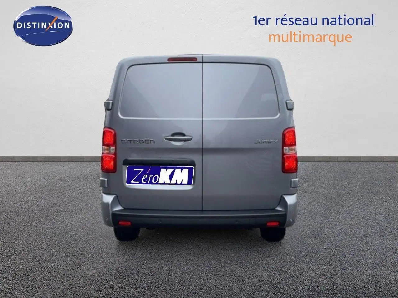 Vue arrière d’un Citroën Jumpy gris Artense métal, fourgon fermé avec feux rouges visibles et plaque Zero KM.