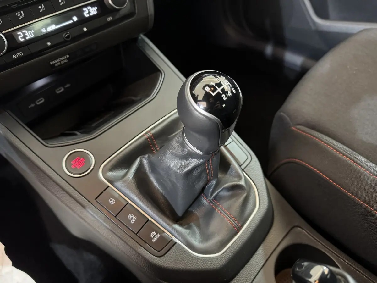 Gros plan sur le levier de vitesses manuel noir avec coutures rouges dans l’habitacle d’une SEAT Ibiza 2024.