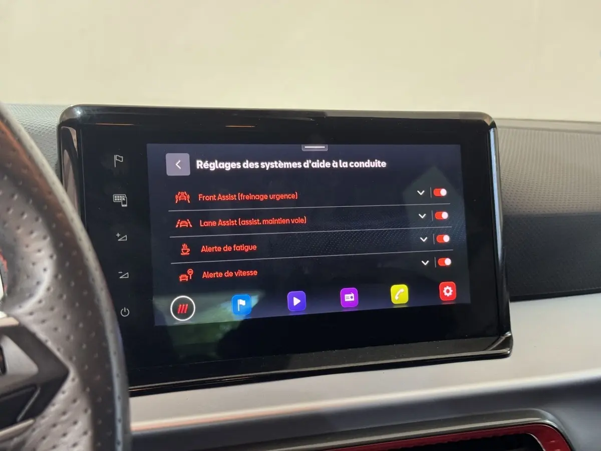 Écran tactile central affichant les réglages d’aide à la conduite dans l’habitacle d’une SEAT Ibiza rouge.