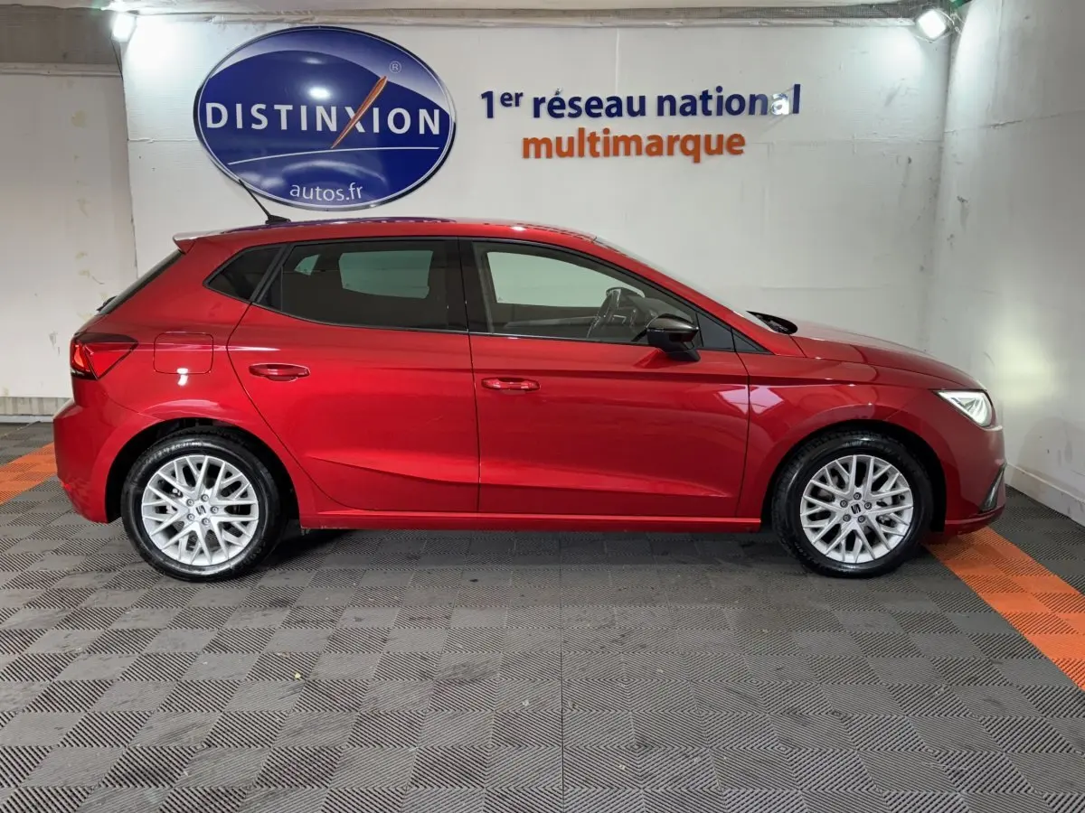 Profil côté gauche de la SEAT Ibiza 1.0 TSI 110 FR rouge 2024 avec jantes alliage et lignes dynamiques visibles.