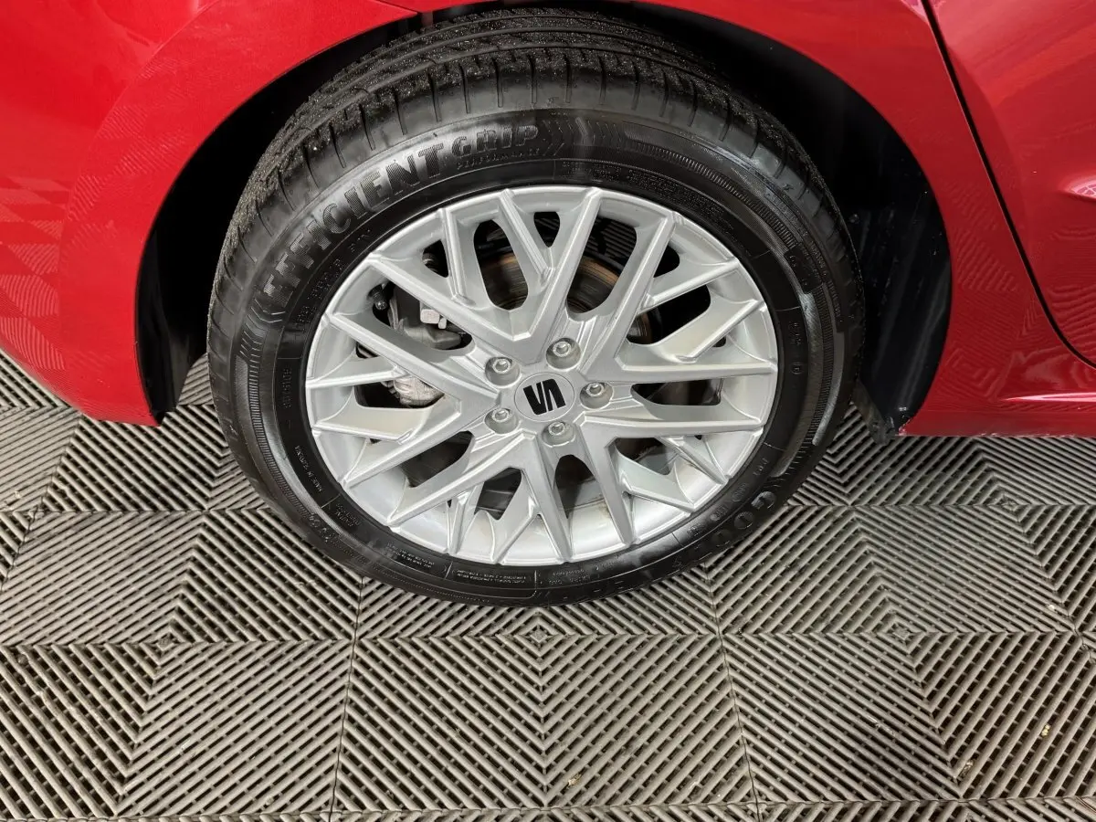 Gros plan sur la roue avant droite d'une SEAT Ibiza rouge 2024, mettant en valeur la jante alu argentée multi-branches.