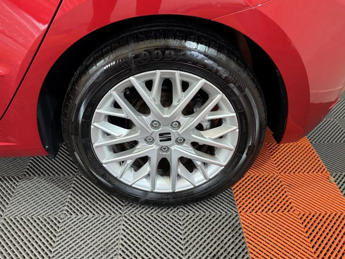 Gros plan sur la roue avant droite d’une SEAT Ibiza rouge 2024 avec jante alu à multiples branches.