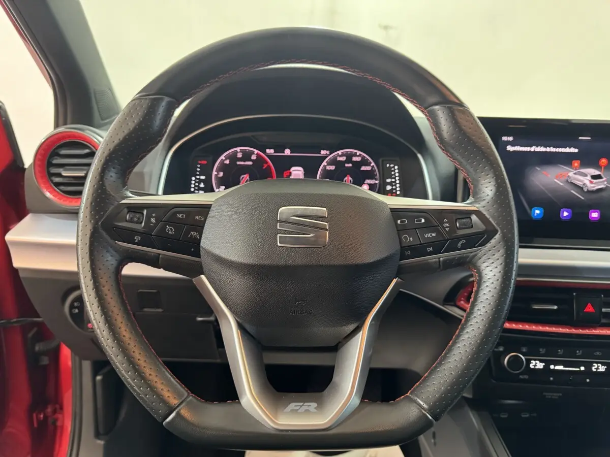 Volant cuir et alu de SEAT Ibiza 1.0 TSI 110 FR rouge, vue frontale centrée sur le tableau de bord numérique et écran tactile.