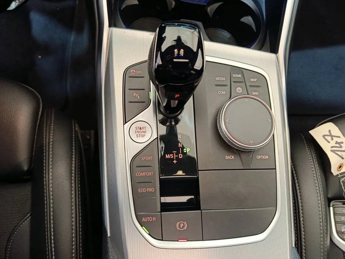 Vue rapprochée de la console centrale BMW Série 3 318d 2022 avec levier de vitesse noir et boutons de mode de conduite.