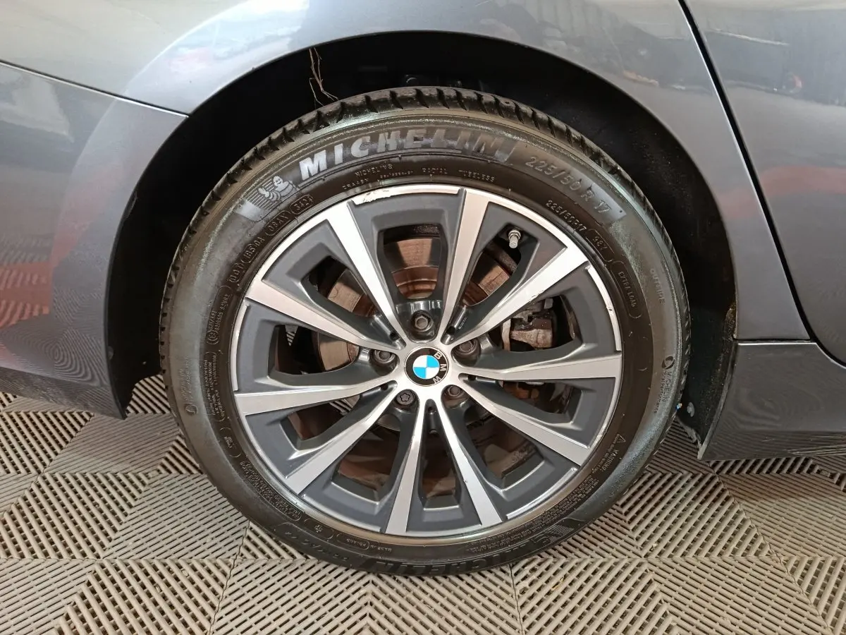 Gros plan sur la roue arrière droite gris clair d'une BMW Série 3 318d Lounge 2022 avec jante alliage et pneu Michelin.