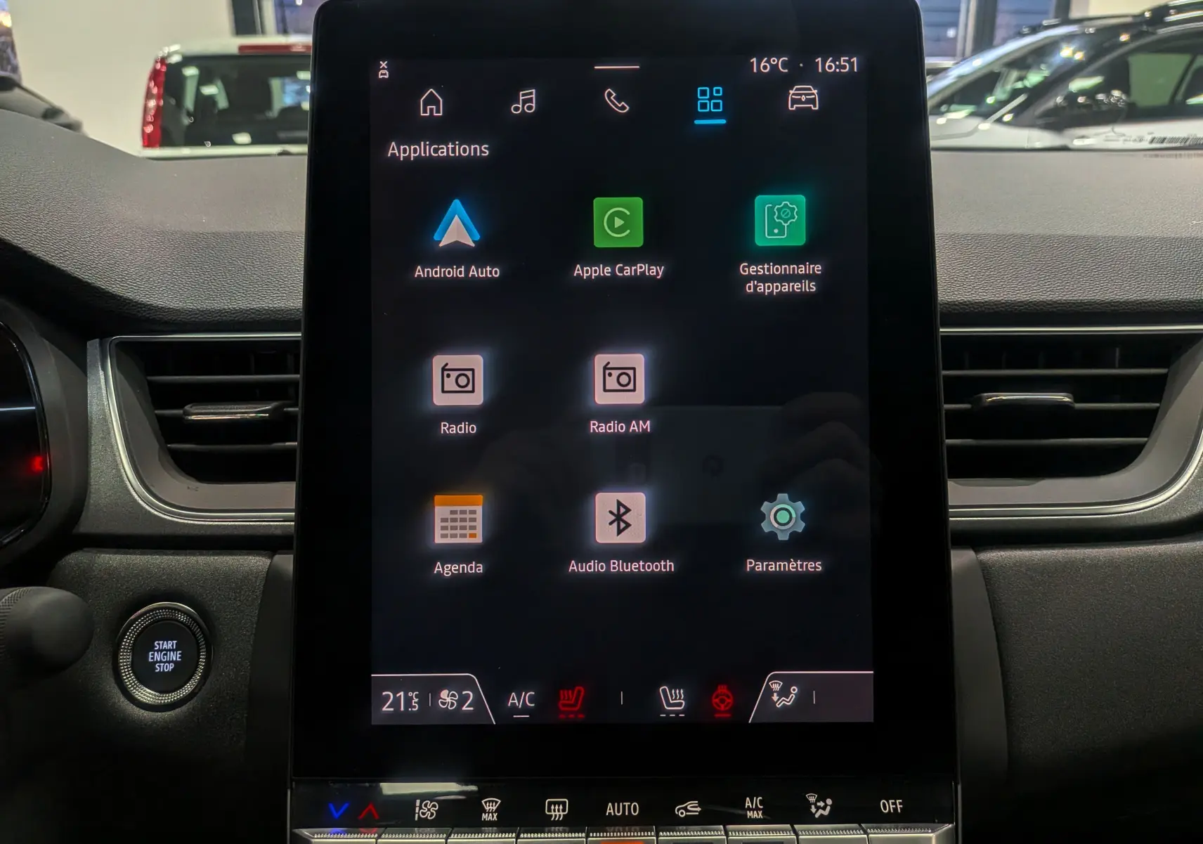 Écran tactile central allumé du Renault Captur Gris Cassiopé, vue frontale de l'habitacle avec commandes climatisation visibles.