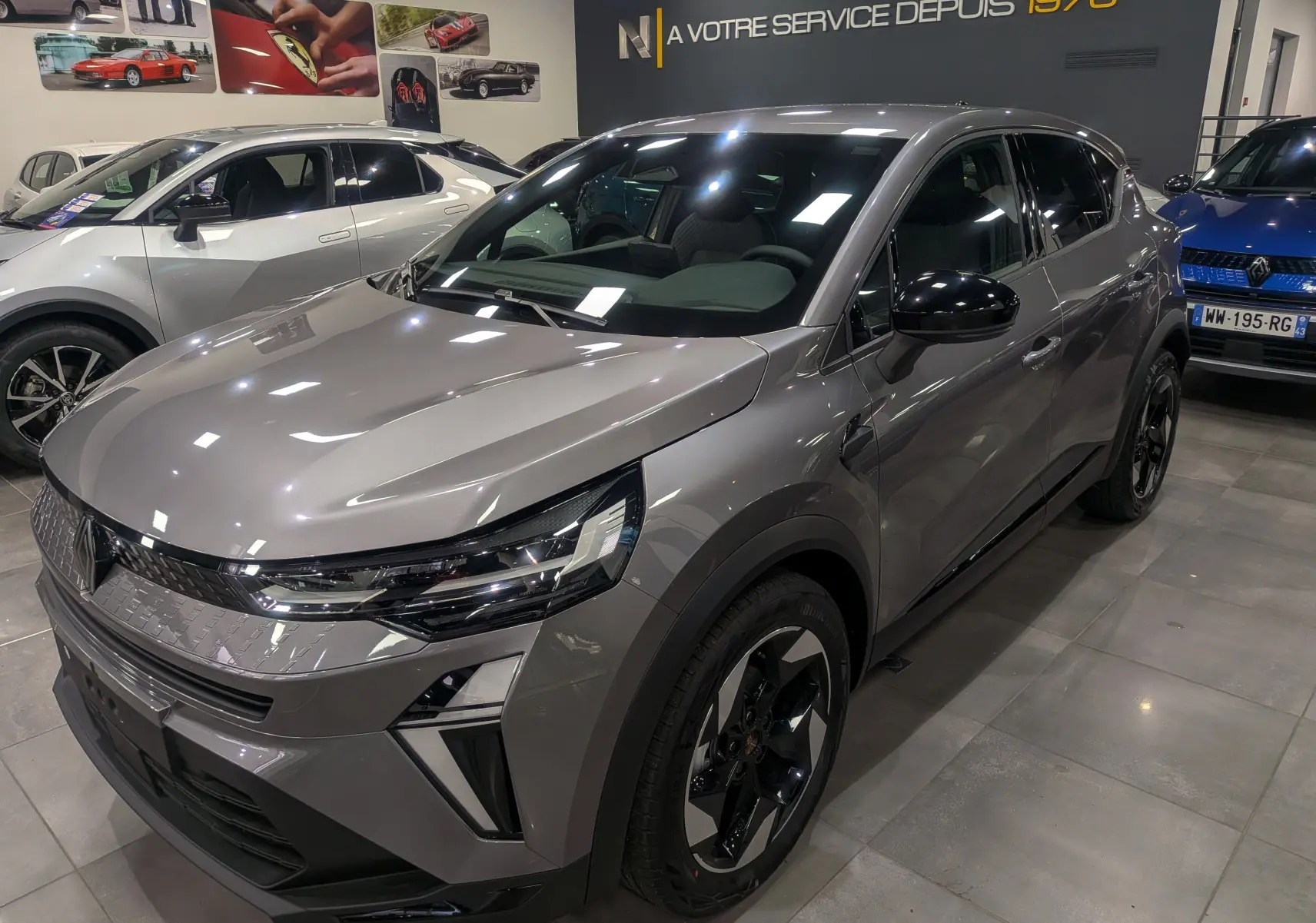 Renault Captur Mild Hybrid 160 CH EDC TECHNO gris Cassiopé vu en 3/4 avant droit dans un showroom lumineux.