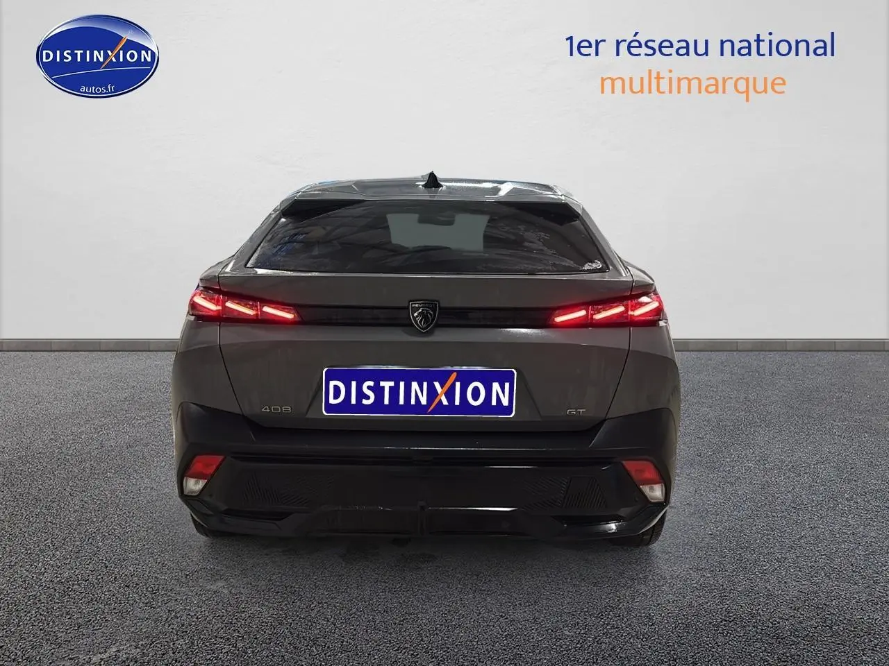 Vue arrière d'une Peugeot 408 Hybrid gris sellenium avec feux LED allumés et logo central visible.