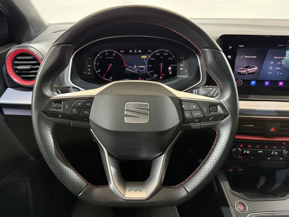 Vue rapprochée du volant en cuir et alu avec logo SEAT, tableau de bord numérique et écran tactile du SEAT Ibiza 2024 noir.