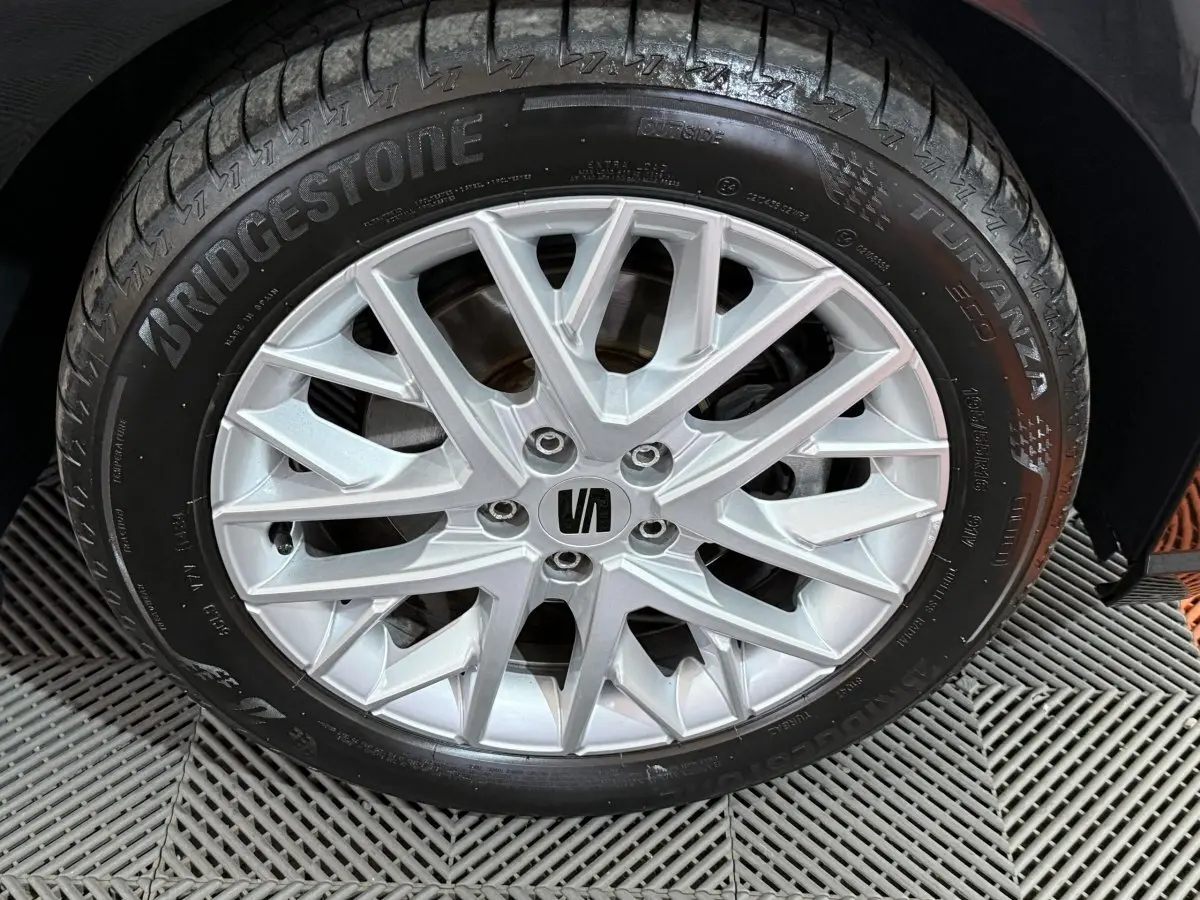 Gros plan sur la roue avant droite d'une SEAT Ibiza noire 2024, jante alliage argentée et pneu Bridgestone Turanza.