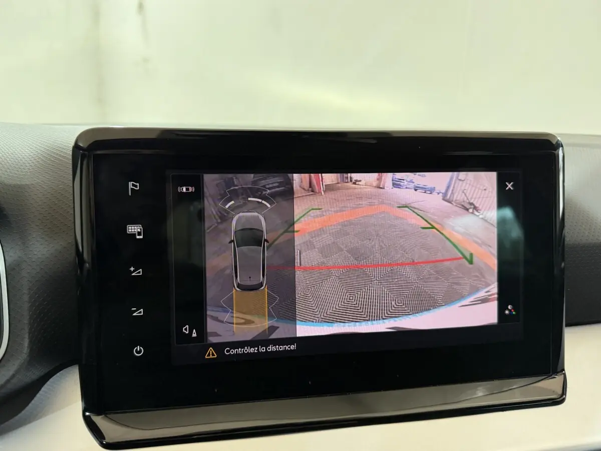 Écran tactile intérieur montrant la caméra de recul et l’aide au stationnement d’une SEAT Ibiza noire.