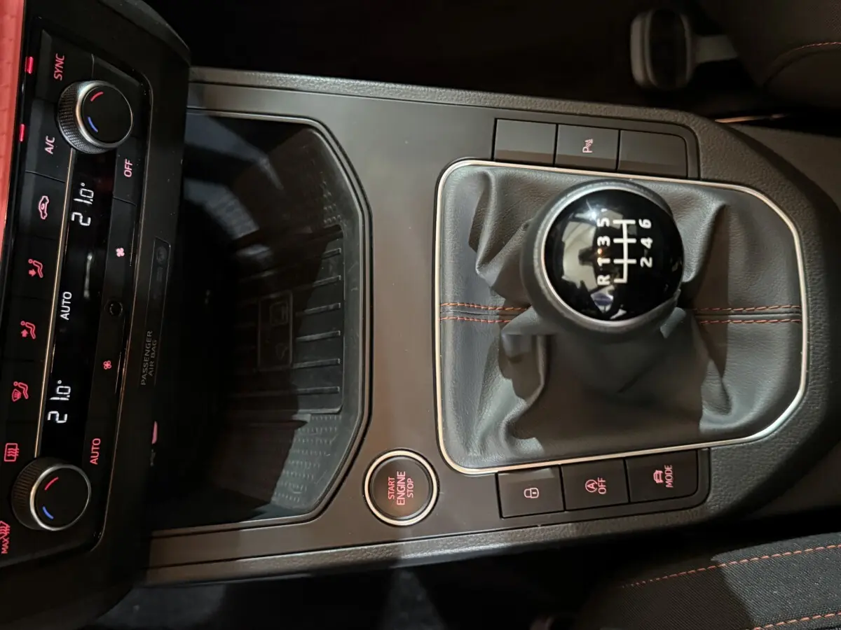 Vue rapprochée de la console centrale noire de la SEAT Ibiza 1.0 TSI 110 FR 2024, avec levier de vitesses manuel et bouton start/stop.