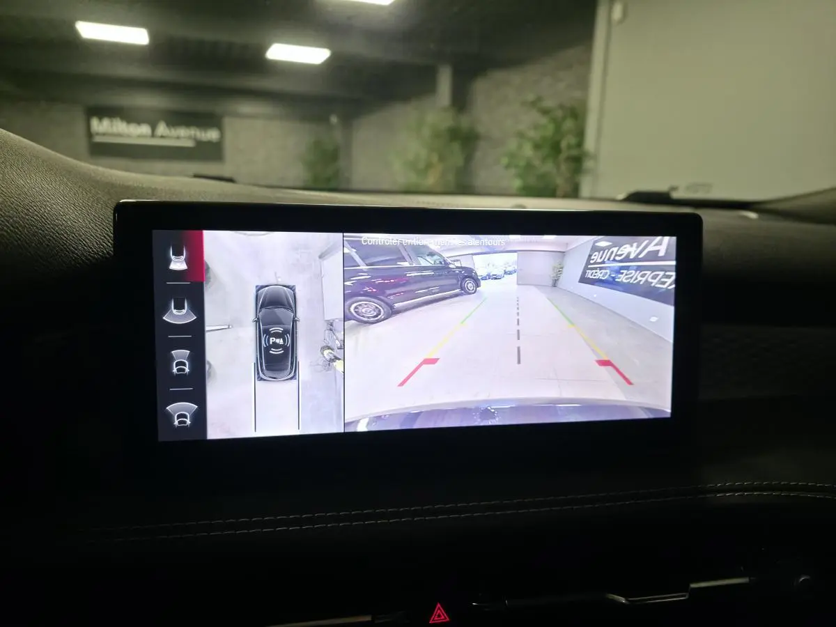 Écran tactile intérieur affichant la caméra 360° de l'Alfa Romeo Tonale rouge, vue arrière en parking intérieur.