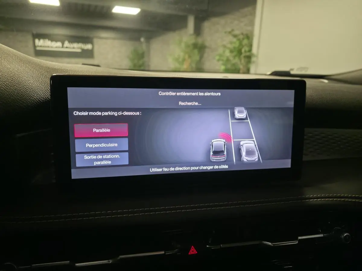 Écran tactile intérieur affichant l'aide au stationnement 360° du SUV Alfa Romeo Tonale rouge, vue de face cabine.