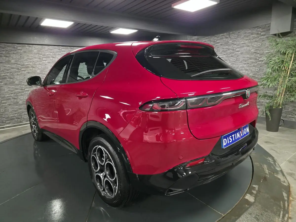 Vue 3/4 arrière droite de l'Alfa Romeo Tonale rouge avec jantes 18 pouces et feux arrière full LED.