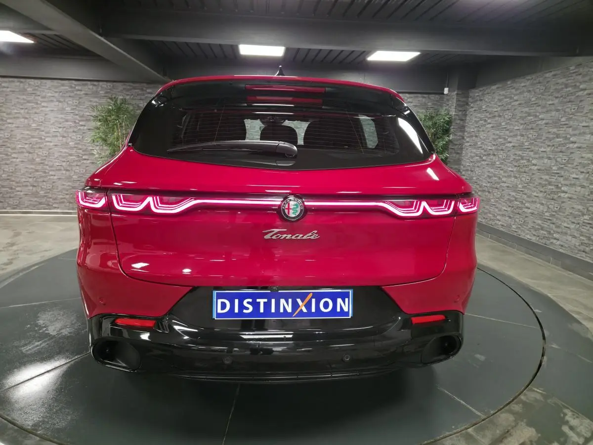 Vue arrière d'une Alfa Romeo Tonale rouge avec feux LED distinctifs et diffuseur noir brillant.